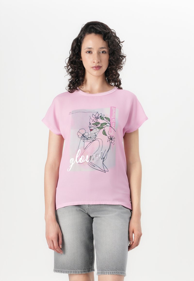 Pink short-sleeve T-shirt featuring a graphic design with floral accents, and the text "Believe in yourself" in silver lettering.