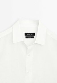 Witte linnen shirt met een klassieke kraag, een knopenlijst met parelmoer knopen en een label met "Massimo Dutti" branding.