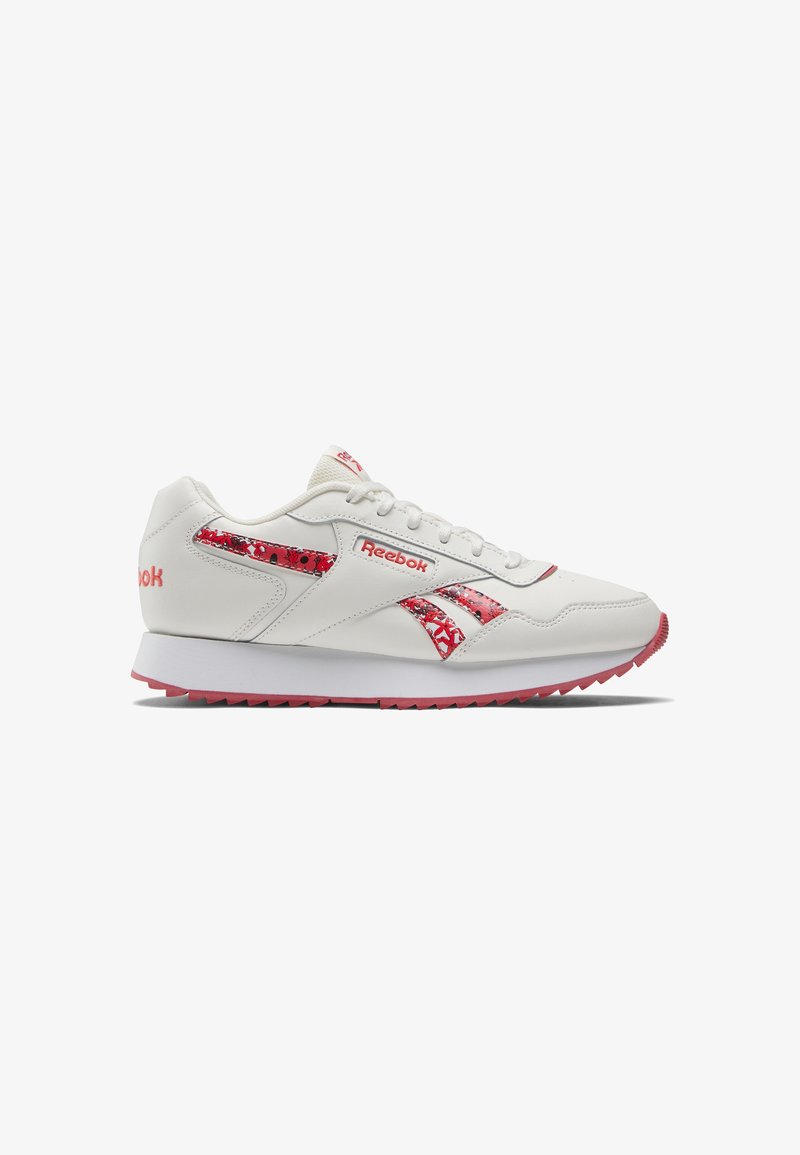 White athletic sneakers with red accents, featuring a smooth leather upper, patterned detailing, and a rubber outsole for traction.