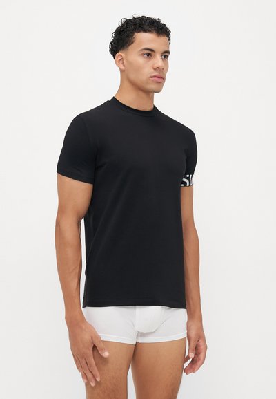 Schwarzes Kurzarm-T-Shirt mit rundem Halsausschnitt, aus glattem Stoff gefertigt. Verfügt über einen weißen Logo-Akzent am linken Ärmels.