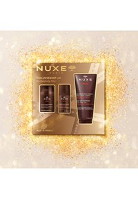 NUXE presentset som innehåller tre bruna behållare: en deodorant, en återfuktande kräm och en mångsidig duschgel, allt presenterat i en guldåda.