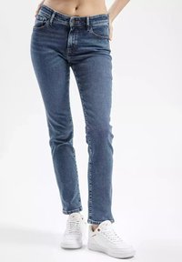 Niebieskie dżinsy o slim fit i prostych nogawkach, z zapięciem na guzik, pięcioma kieszeniami i lekko wyblakłą teksturą.