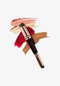 Barra de maquillaje de doble extremo de Revlon con un diseño negro y dorado, junto a muestras de tonos beige, rosa, rojo y marrón.
