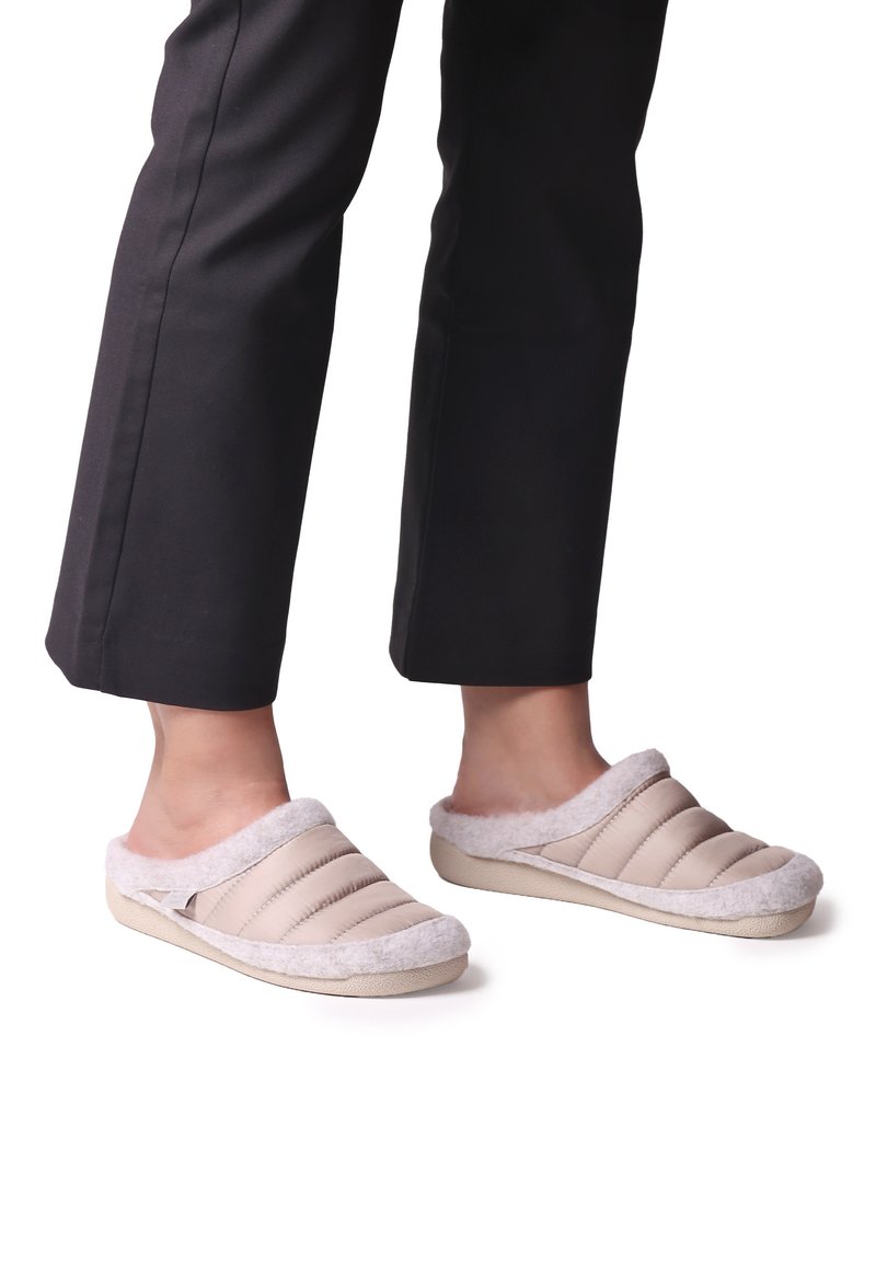 Zapatillas de casa beige sin cordones con parte superior acolchada, suave forro de piel de grosella gris y suela de goma; cuentan con cortes laterales para mayor transpirabilidad.