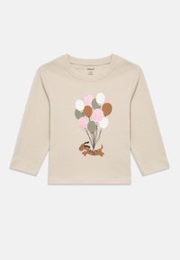 Μπεζ πουκάμισο με μακριά μανίκια, με ένα γραφικό σκύλου που κρατά ένα σύνολο μπαλονιών σε ροζ, λευκό, καφέ και πράσινο χρώμα.