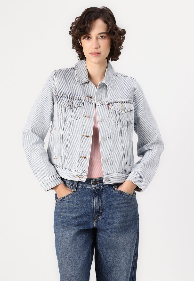 Lichtblauwe denimjack met een cropped ontwerp, twee borstzakken en knoopsluiting. Gelaagd stof met verticale strepen.