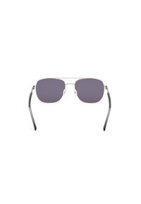 Gafas de sol con un marco de metal plateado, forma rectangular, lentes de color gris oscuro y puntas de las patillas de plástico negro. Almohadillas nasales transparentes adjuntas.