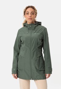 Giacca impermeabile verde con cappuccio, chiusura a zip frontale e due tasche laterali. Caratterizzata da cordini sul cappuccio e sui polsini. Leggera, con texture liscia.