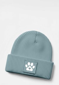 Blue ribbed beanie with a folded cuff featuring a square patch displaying a white paw print and heart design. Soft texture, knit material.