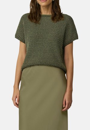 Knit short-sleeve top in olive green, featuring a textured pattern. Paired with a smooth, light green skirt, creating a layered look.