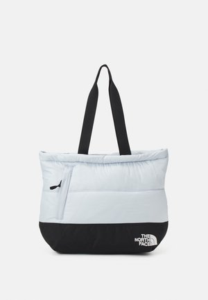 Grand sac fourre-tout gris clair et noir avec texture matelassée, poignées noires, poche zippée latérale et logo blanc The North Face en bas à droite.