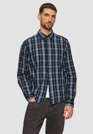 Marineblauwe en witte geruite shirt met een button-down kraag, lange mouwen en een voorzak; gecombineerd met donkergrijze broek.