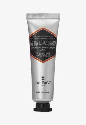 Aluminiumtube mit Handcreme; silber mit schwarzen und orangefarbenen Akzenten. Der Text lautet "nährende Handcreme" und listet die wichtigsten Inhaltsstoffe auf. 30 ml Größe.
