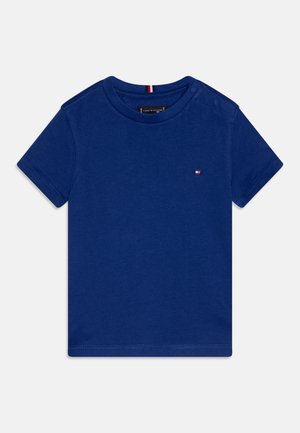 Blaues Baumwoll-T-Shirt mit kurzen Ärmeln, Rundhalsausschnitt und einem kleinen Logodetail auf der Brust. Verfügt über Druckknöpfe an der Schulter für ein einfaches Anziehen.