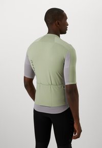 Kurzärmliges Radtrikot in Hellgrün und Grau, aus strukturiertem Material, mit einem Reißverschluss-Rückenfach und einer taillierten Passform.