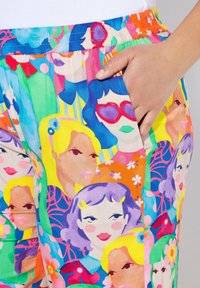 Barevné kalhoty se vzorem mají design s různými stylizovanými obličeji, převážně v růžové, žluté, zelené a modré barvě. Elastický pas, boční kapsa.