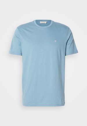 Ανοιχτό μπλε βαμβακερό μπλουζάκι με στρογγυλή λαιμόκοψη, κοντά μανίκια και ένα μικρό λευκό λογότυπο στο στήθος. Λείος υφαντός, απλός σχεδιασμός.