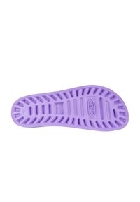 Suela de zapato de goma morada con patrones de agarre texturizados y líneas indentadas para tracción. Presenta una marca elevada en el centro.
