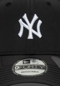 Μαύρο καπέλο μπέιζμπολ με λευκό κεντημένο λογότυπο "NY". Ρυθμιζόμενος ιμάντας με στρογγυλή ετικέτα που αναγράφει "9FORTY" και "NEW ERA". Ομαλή υφή.