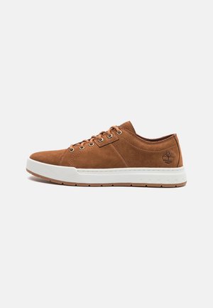 Baskets basses en cuir marron avec semelle en caoutchouc blanc et lacets, logo de l'arbre Timberland embossé près du talon sur le côté extérieur.