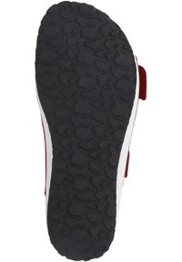 Black rubber shoe sole with a textured pattern. White midsole with red accents visible on the sides. Flat and wide design.