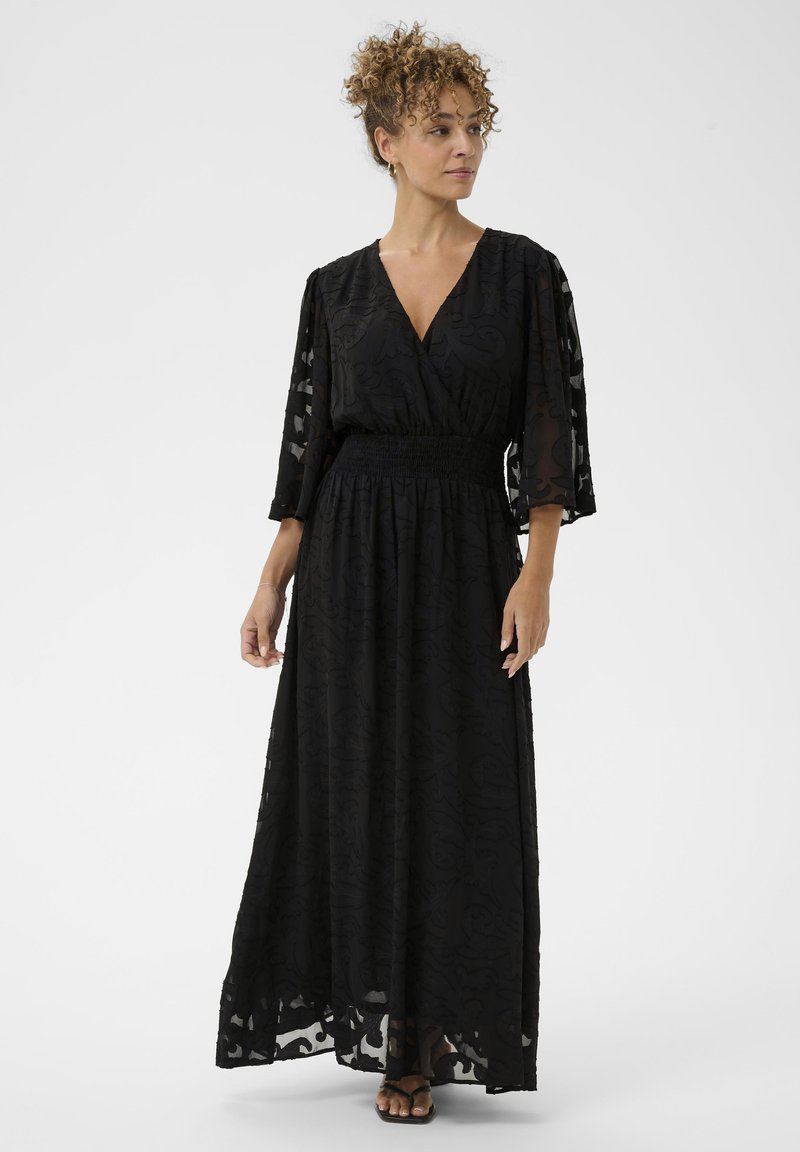 Fekete maxi ruha V nyakkivágással, átlátszó hímzett anyagból, háromnegyedes ujjal, és smockolt derékkal, amelynek laza szoknyája van.