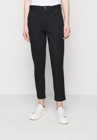 Černé bavlněné chinos kalhoty se slim fit střihem, zkrácenou délkou a ohrnutými manžetami. Mají pas s požadavkem na knoflík a přední kapsy.