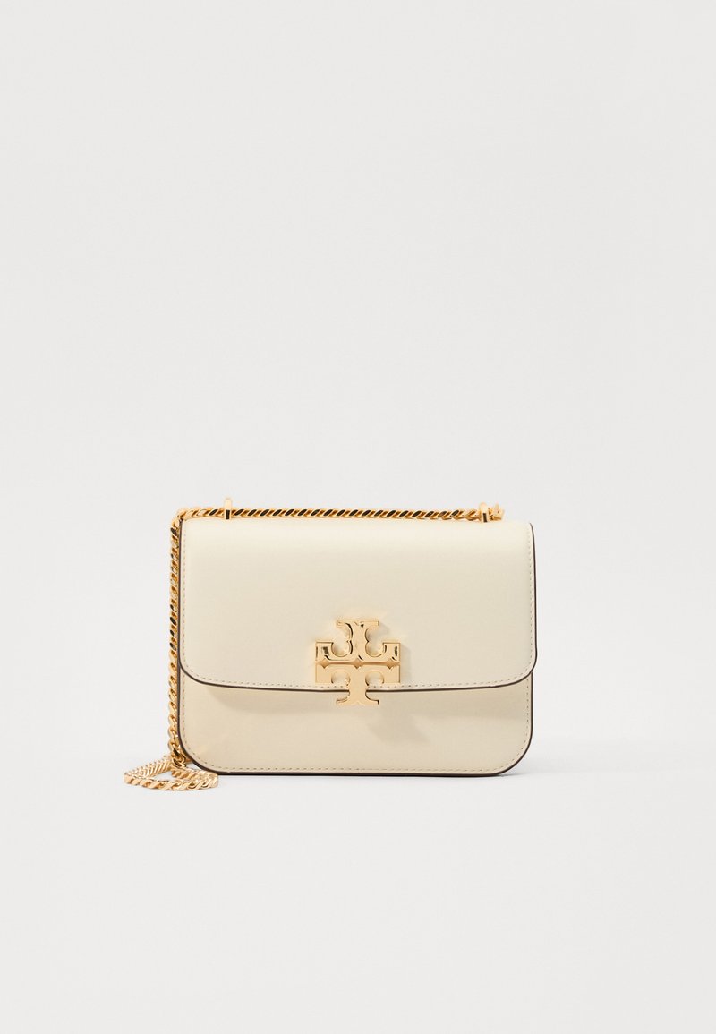 Cream leather crossbody bag with a gold chain strap, featuring a gold logo accent on the front and clean, sleek lines.
