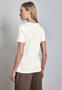 Hvid kortærmet t-shirt med rund halsudskæring, lavet af blødt bomuld, med et enkelt design og en let formsyet silhuet.