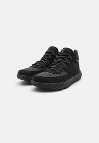 Sneaker alte nere realizzate in materiale testurizzato con perforazioni, accenti in rete e suole in gomma robuste con un pattern di grip pronunciato.