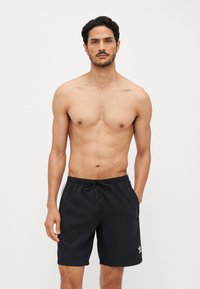 Sorte svømmebukser med elastisk talje og snøre. Har sidelommer og en hvid logoaccent. Glat stof med en afslappet pasform.