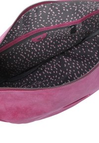 Borsa in suede rosa con chiusura a zip, caratterizzata da una fodera nera con un motivo a pois rosa chiaro e una tasca interna.