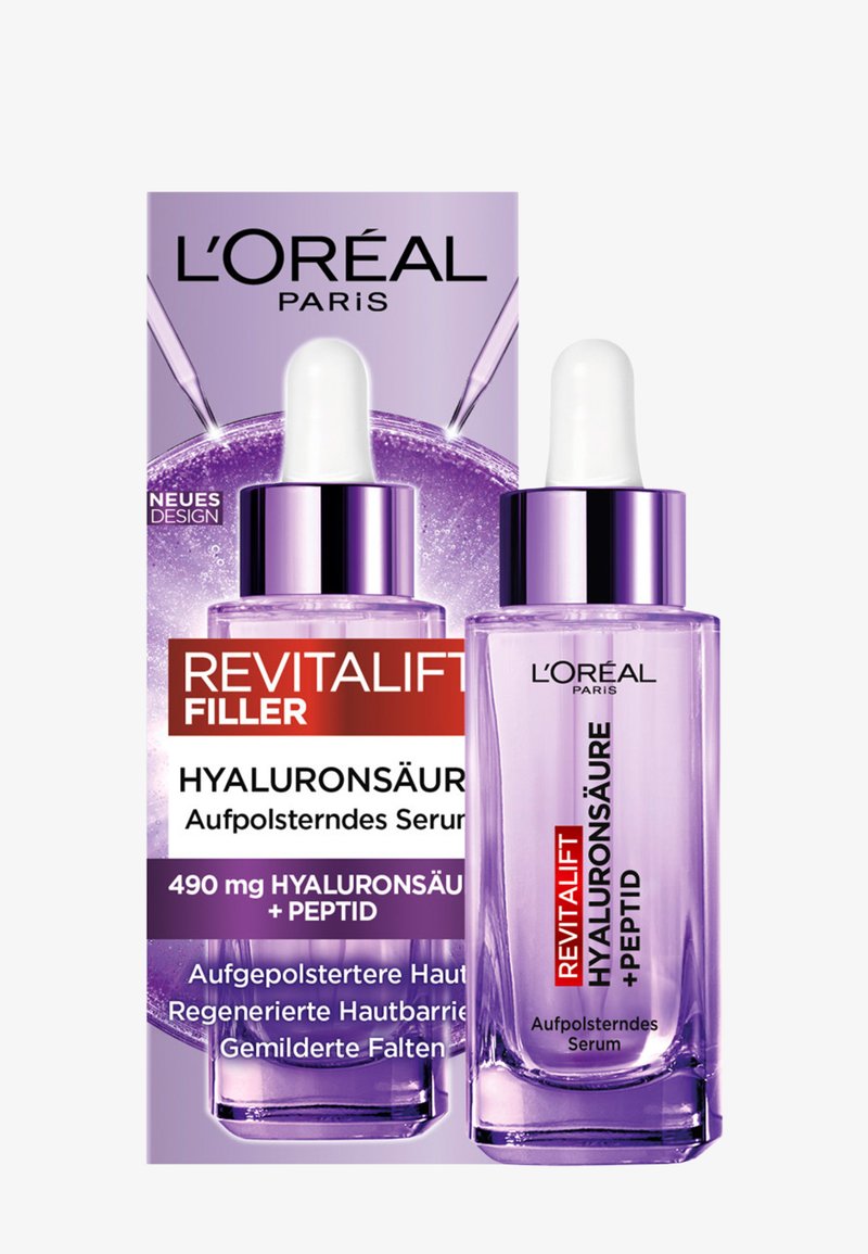 Sérum à l'acide hyaluronique L'Oréal Revitalift Filler avec peptide dans un flacon compte-gouttes violet transparent à côté de sa boîte assortie.