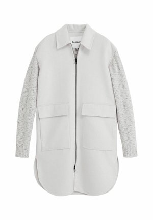 Hellgraue Jacke mit weicher Außenfläche, versehen mit strukturierten grauen Strickärmeln, zwei vorderen Taschen und einem Reißverschluss. Abgerundeter Saum.