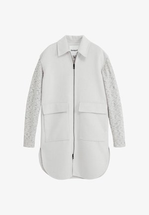 Hellgraue Jacke mit weicher Außenfläche, versehen mit strukturierten grauen Strickärmeln, zwei vorderen Taschen und einem Reißverschluss. Abgerundeter Saum.