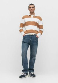 Randig tröja i brunt och vitt, med krage. Matchas med blå denimjeans och mörka sneakers med vita detaljer.