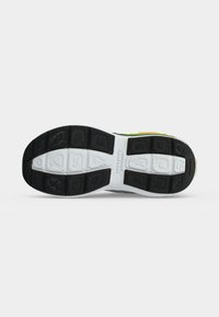 Semelle de chaussure avec une semelle en caoutchouc noire et blanche et le nom de la marque Skechers embossé au centre.