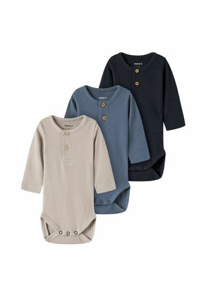Trois bodies bébé à manches longues côtelés en beige, bleu et noir avec des boutons en bois sur la poitrine et des pressions en bas.