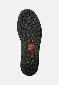 Suela de zapato con diferentes relieves circulares en relieve, un logo circular rojo que dice "camper" y el tamaño 42 marcado debajo del logo.
