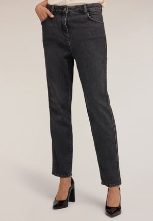 Jeans in denim nero con una vestibilità dritta, vita alta, cuciture tono su tono e dettagli con zip laterale. Abbinati a tacchi neri lucidi.