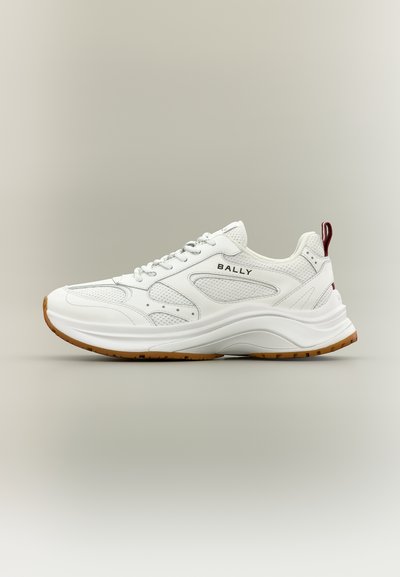 Baskets blanches Bally avec panneaux en mesh et cuir, semelle blanche épaisse, semelle extérieure marron, lacets et languette rouge au talon.