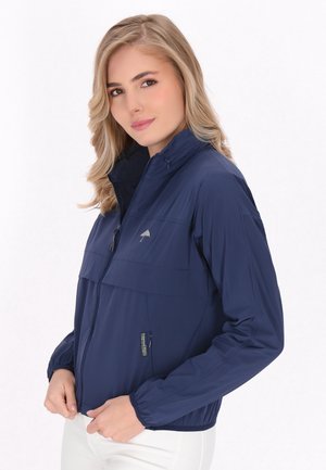 Mørkeblå letvægtsjakke med splitfront, elastiske manchetter og i et to-farvet design. Har et logo på brystet og en sidelomme.