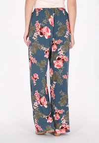 Bloemrijke wijde broek gemaakt van lichtgewicht stof, met een marineblauwe achtergrond en grote roze en groene bloempatronen. Met elastische tailleband.