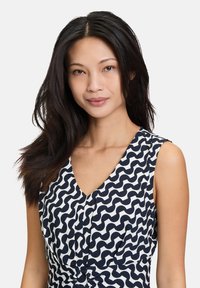 Ärmelloses Kleid mit einem wellenförmigen Muster in Navyblau und Weiß, V-Ausschnitt und geknotetem Detail an der Taille. Glatte Stofftextur.