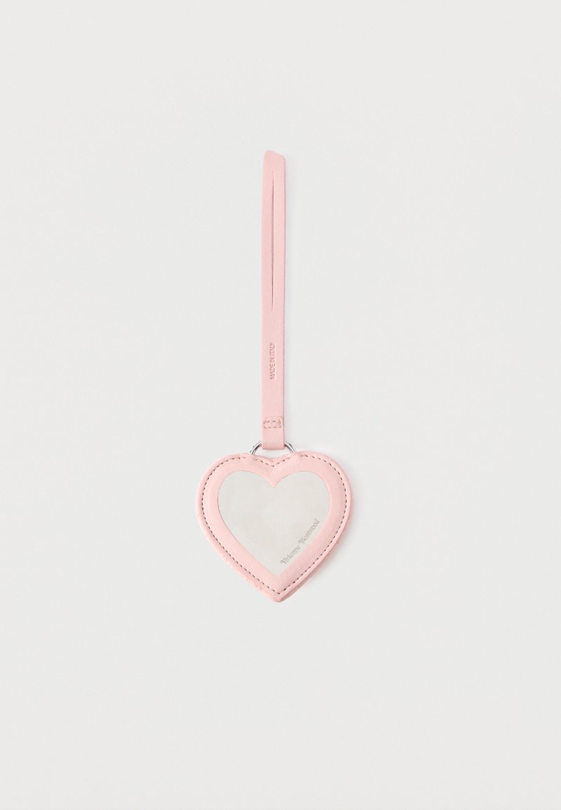 Etichetta per bagaglio in pelle rosa a forma di cuore con finestra trasparente e cinghia allegata su sfondo bianco uniforme.