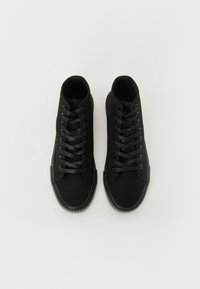 Tenisi negri în stil high-top cu ușă din pânză, talpă din cauciuc texturat și șireturi plate negre. Prezintă un vârf rotund și nu au branding vizibil.