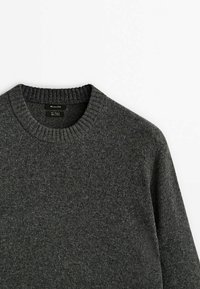 Pull en tricot gris foncé avec un col rond côtelé et une texture douce. Aucun motif ni élément métallique visible ; il présente un design simple et classique.