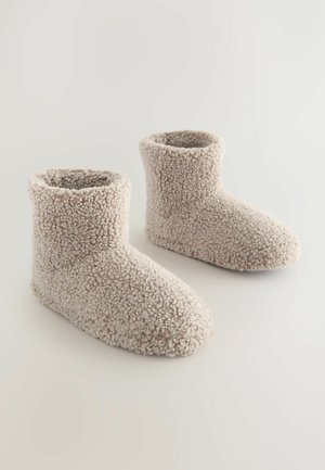 Pantofole in felpa beige, con esterno morbido eTexture, altezza alla caviglia, punta rotonda e cuciture rinforzate per una maggiore durata.
