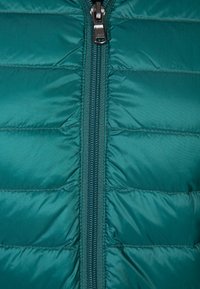 Turkusowa kurtka puchowa z pełnym zamkiem błyskawicznym, pikowanym wzorem z widoczną ociepliną oraz gładkim, błyszczącym wykończeniem.