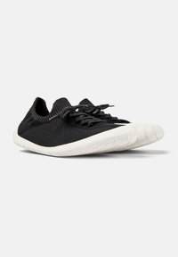 Scarpa sportiva nera con una tomaia testurizzata, design a profilo basso e suola in gomma bianca. Presenta lacci e puntale rinforzato per un maggiore supporto.